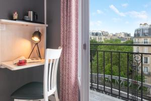 巴黎Hôtel Baldi by Magna Arbor的客房设有书桌和带窗户的阳台