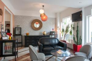 巴黎Hôtel Baldi by Magna Arbor的客厅配有黑色真皮沙发和椅子