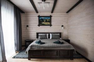 库尼贡达Chalet Carpat Dream的一间卧室,配有一张带两顶帽子的床