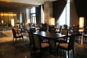 蚌埠蚌埠富力万达嘉华酒店的用餐室设有桌椅和窗户。