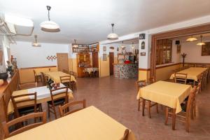 SlapPenzion Na Hribu的配有木桌和桌椅的餐厅