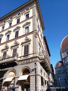 佛罗伦萨Palazzo Gamba Apartments al Duomo的大街上一座高大的白色建筑,窗户