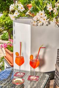 卡普里Villa Giardini Luxury Room的桌上的两杯鸡尾酒,鲜花盛开