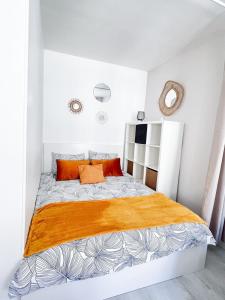 蒙特罗福约讷Ô Confluent的白色卧室配有带橙色枕头的大床