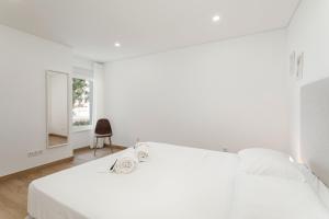 维拉摩拉Premium Apartment in the Center of Vilamoura - Cota10 by Centralgarve的白色卧室配有一张大床和椅子