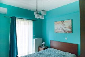 普雷韦扎Meropi Apartment的蓝色的卧室设有床和窗户