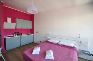 热那亚H2Ome Ponte Morosini的一间带粉红色床的卧室和一间厨房
