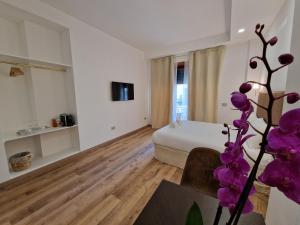 罗马Cuma Suites的一间设有一张床铺和一张紫色花卉桌子的房间