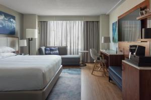 坦帕Tampa Marriott Water Street的酒店客房配有一张床、一张沙发和一张书桌。