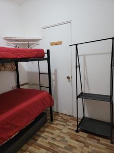 圣地亚哥Hostal Pura Vida的带两张双层床和一扇门的房间