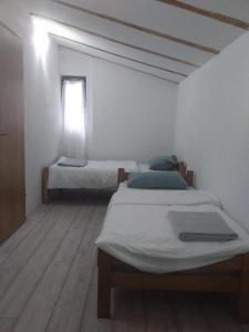 格拉迪什卡Apartmani Primus的白色客房的两张床,设有窗户