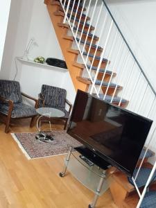 申瓦尔德Haus Lucia, mit Pool und Sauna, Appartment 4的一间带电视和楼梯的客厅