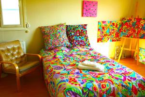 YlitornioWarm ART room at home.的一间卧室配有一张色彩缤纷的床和一把椅子