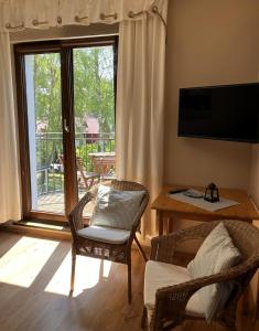 波别罗沃Apartamenty Villa 28的客厅配有两把椅子、一张桌子和一扇窗户