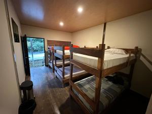 圣安娜Captain Morgan Hostel Lake Coatepeque的客房设有两张双层床和一个阳台。