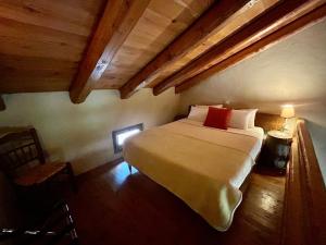 PolídhrosonPritanio的一间带一张大床的卧室,位于一个拥有木制天花板的房间