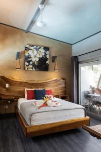 乌维塔Hotel FAREMITI Uvita的一间卧室配有一张大床和木制床头板
