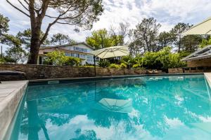 比达尔SERENITY - KEYWEEK Bidart swimming pool villa的一座房子前面的蓝色海水游泳池