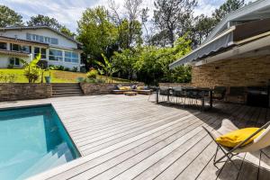 比达尔SERENITY - KEYWEEK Bidart swimming pool villa的一个带游泳池、椅子和房子的甲板