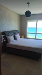 弗尼迪克AppartF3 vue panoramique sur mer的一间卧室设有一张大床和一个窗户。