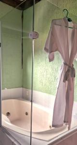 佩尼多博尔德露台酒店的浴缸配有淋浴帘和浴袍
