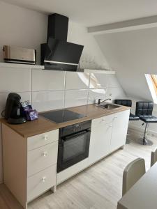 格拉Apartment Ferien Wohnung 4的厨房配有白色橱柜和炉灶烤箱。