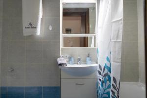 沃洛斯Anesis Suites的一间带水槽和镜子的浴室