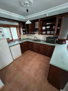 萨潘贾Four seanson müstakil sıcak havuzlu villa的厨房配有木制橱柜和瓷砖地板。