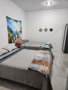 瓜纳华托Casa Linda Vista的卧室配有两张床,墙上挂有壁画