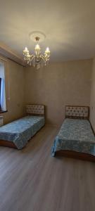 苏姆盖特Caspian Seaside Villa的一间卧室配有两张床和吊灯。