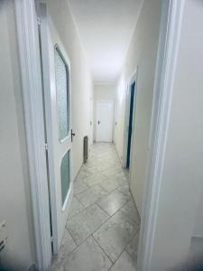 加利波利Dimora Chanel Gallipoli 30mt dal mare的走廊设有白色门,铺有瓷砖地板