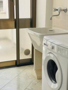 加利波利Dimora Chanel Gallipoli 30mt dal mare的一间带盥洗盆的浴室内的洗衣机