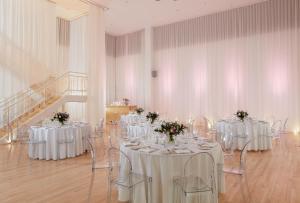 伦敦Sanderson London的一间设有白色桌椅和鲜花的房间