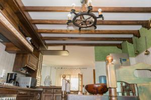 科里亚CASA RURAL EL ZARZOSO的厨房设有木梁天花板和吊灯。