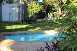 科玛蒂普特伊科拉克斯精品酒店的一座位于庭院的游泳池,庭院里种着树木,房子里