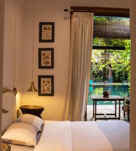 清迈Chandra Residence的一间卧室配有一张床,享有游泳池的景色