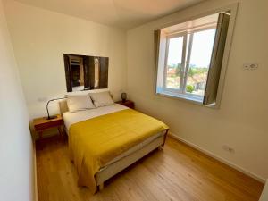 波尔图Uporto House Palace的一间卧室配有一张带黄色床罩的床和窗户