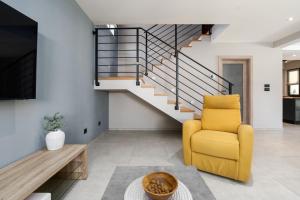 波雷奇Casa Pinia with outdoor jacuzzi的客厅设有黄色椅子和楼梯