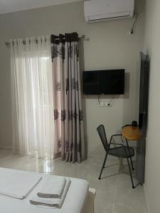 萨兰达Vila Mateo的配有床、椅子和电视的房间