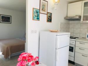 赫瓦尔赫瓦尔安娜公寓的厨房配有白色冰箱和鲜花桌