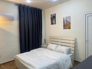 索瓦马lacasa chalet private With a panoramic view of the DeadSea的卧室配有白色的床和蓝色窗帘