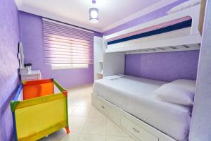 丹吉尔Apartment for rent with 2 bedrooms的紫色卧室配有一张床和双层床