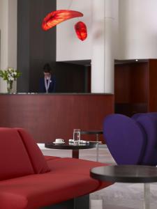 罗希姆诺基马海滩酒店的一间设有红色沙发、桌子和椅子的房间