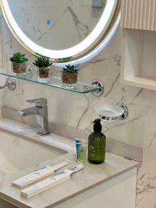 塞拉莱Sky ittin سما إتين的浴室水槽配有镜子和1瓶肥皂