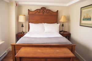 查尔斯敦The General Stanton Inn的一间卧室配有一张带木制床头板的床和两盏灯。