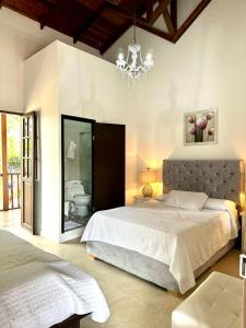 皮塔利托Hotel Colonial Andino - Parque principal de Pitalito的一间卧室配有一张大床和一个吊灯。