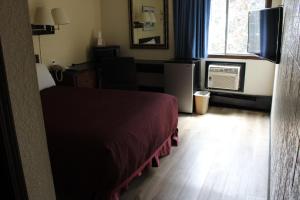 卡利斯佩尔空中旅馆的一间卧室配有一张床、一台电视和一个窗口