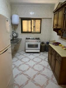阿莱曼قرية جرين بيتش的一间带炉灶的厨房和瓷砖地板