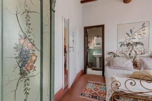 菲耶索莱托里迪佛罗伦萨住宿加早餐旅馆的一间卧室配有一张床,墙上挂着绘画作品