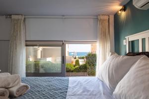 罗希姆诺Oddas Beach House的一间卧室设有一张床和一个大窗户